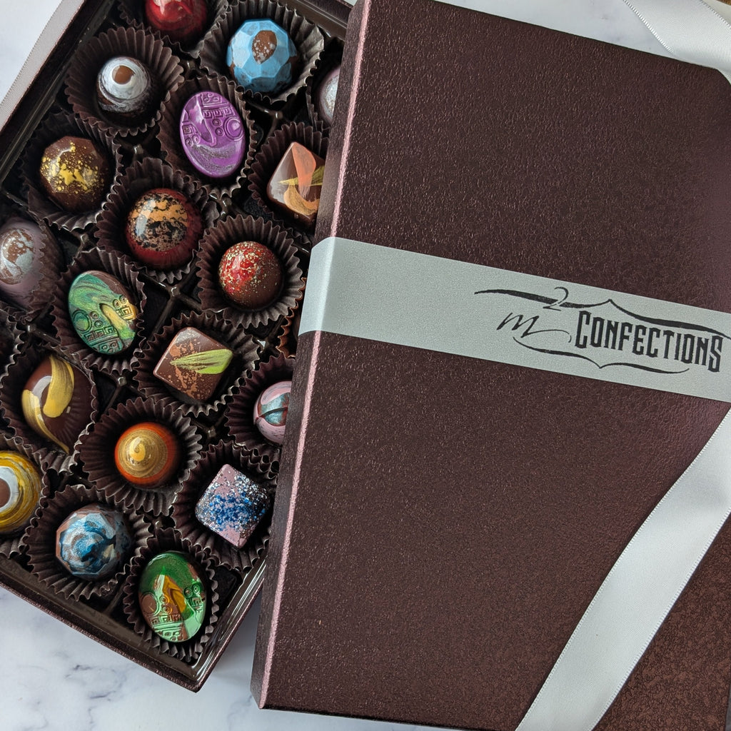 Box of assorted chocolates with a branded box on a marble surface