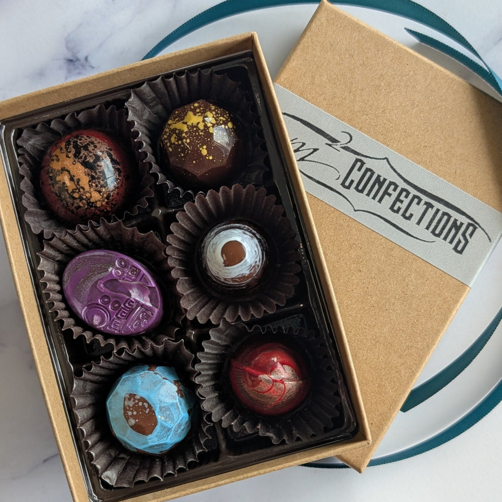 Box of chocolates on a marble surface with 'Confections' branding.