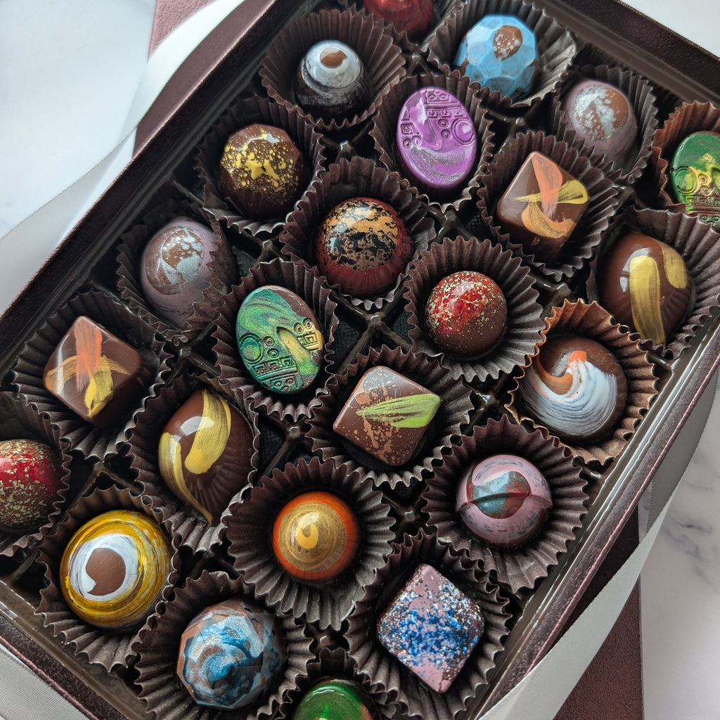 Assorted chocolate truffles in a box on a marble surface