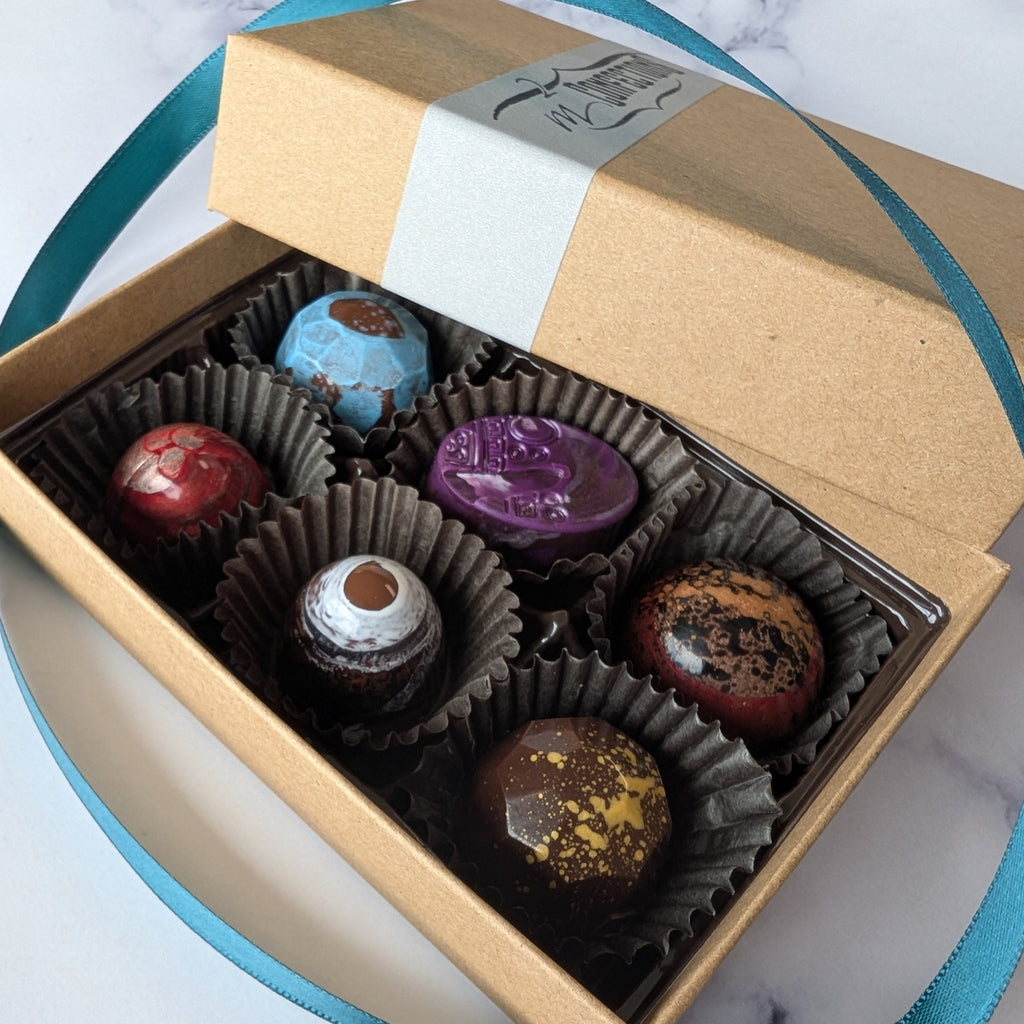 Box of assorted chocolates with a visible brand label on a marble surface