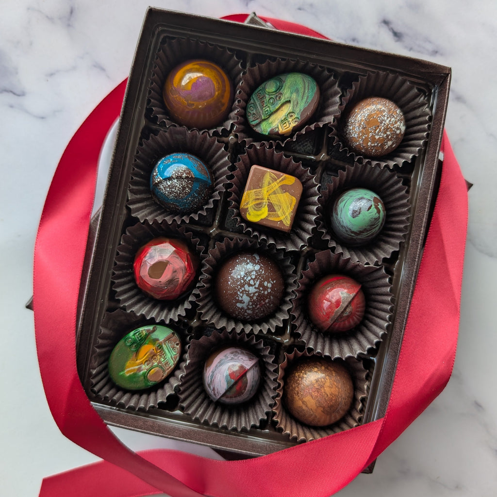 Box of chocolates with colorful covers on a marble surface