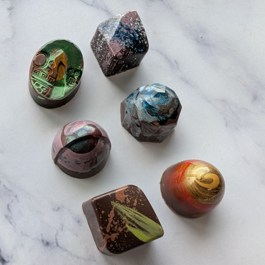 Colorful marbled chocolate truffles on a marble surface