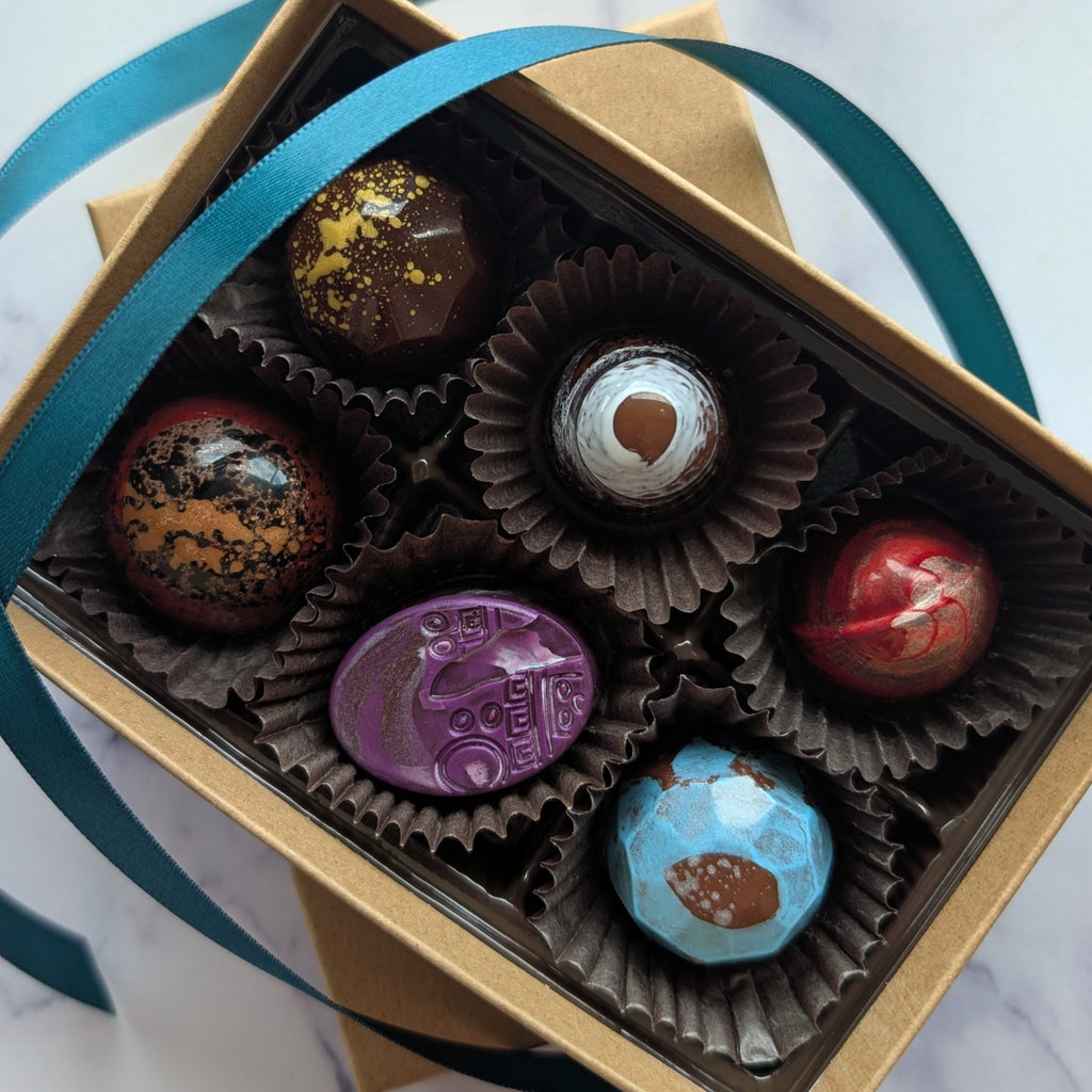 Box of chocolates with a blue ribbon on a marble surface