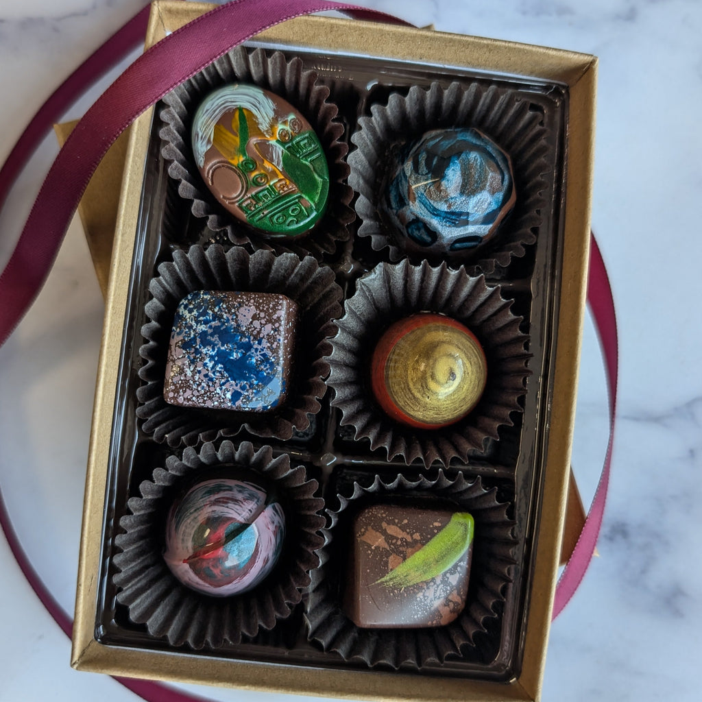 Box of chocolates with decorative wrapping on a marble surface